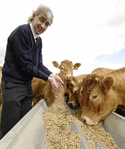 Neil Carr dispenses some of the high quality animal feed of North East Grains Ltd to the cattle of farmer Dave Jordan.