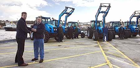 Cameron MacFarlane (second left) of Argyll Agricultural Engineers receives the northern Dealer of the Year award from Landini regional manager Martin Ingram in front of customers who drove their tractors to Oban for the occasion. 