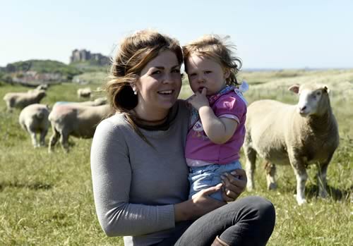 Christina and her daughter Henrietta with Bamburgh Castle in the background