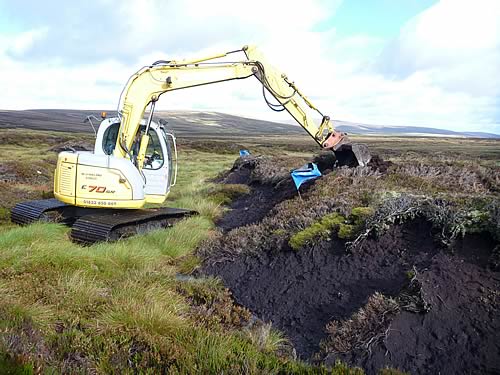 A wide track, low pressure machine re-profiling eroding peat gullies